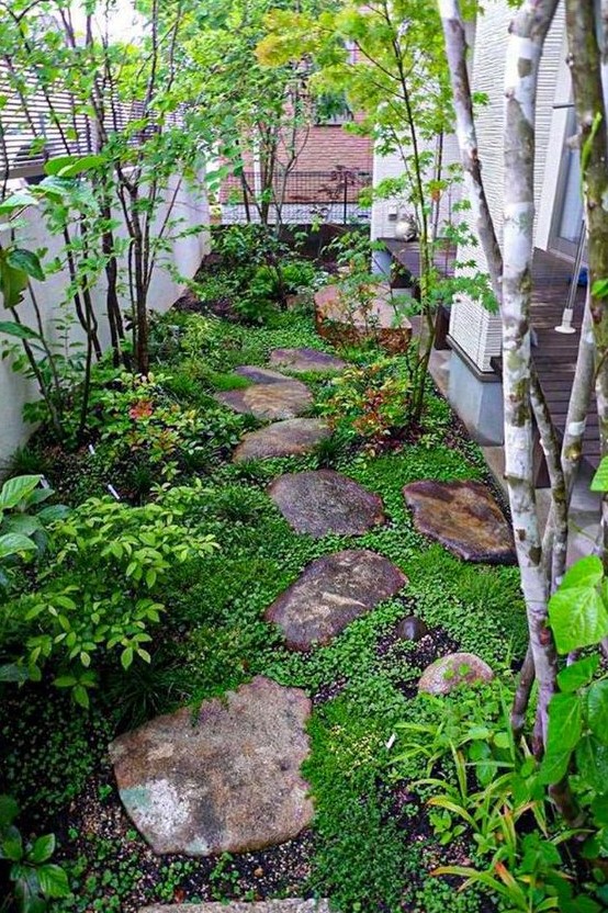 a small Japanese-inspired garden with rocks as pavements, greenery, shrubs and a couple of trees is very peaceful