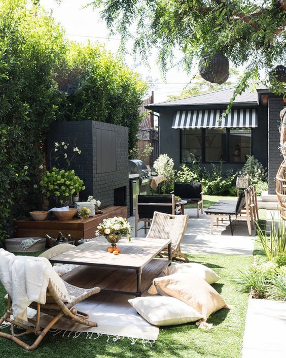 a small backyard that comprises and living room zone and a fireplace zone done in different styles and contrasting colors