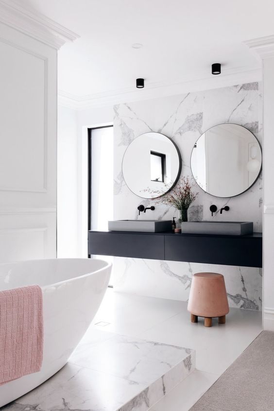 a stylish contemporary bathroom with a black floating vanity and black fixtures plus softening blush touches