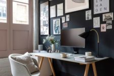 a home office with a black gallery wall