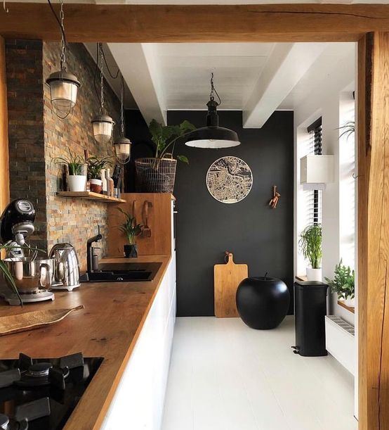 a stylish kitchen with a black accent wall, a statement apple as an art object and black appliances looks wow