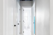 a very narrow and laconic corridor made cool with a bright printed wallpaper ceiling doesn’t look small or boring