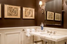 a vintage brown and white bathroom with paneling, a mosaic floor, a sink clad with marble