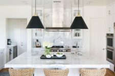 just a couple of black pendant lamps and wicker stools on black legs make the neutral refined kitchen look modern