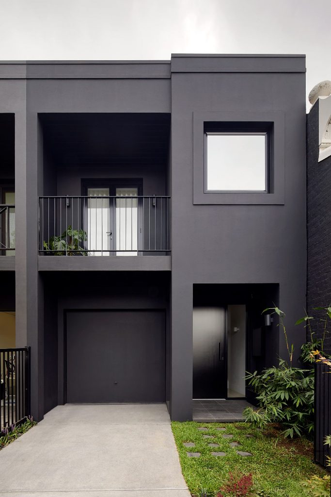 This minimalist house features a black exterior and is refreshed with greenery all around