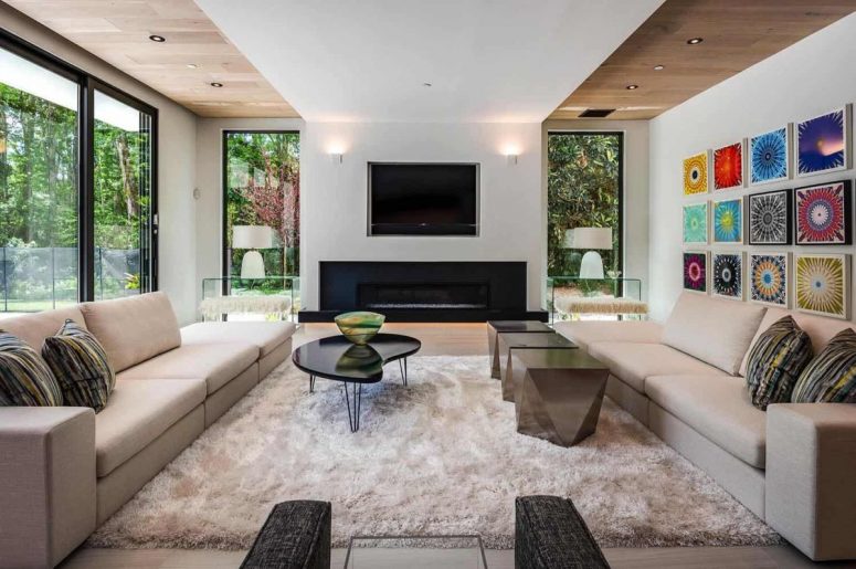 The living room is done with extensive glazing, a built-in fireplace, elegant furniture and rugs