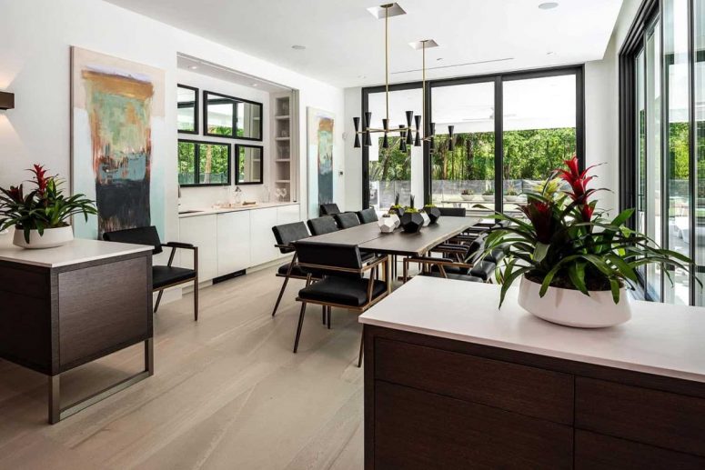The dining room is also light-filled, with stylish dark furniture, black lamps and bold artworks