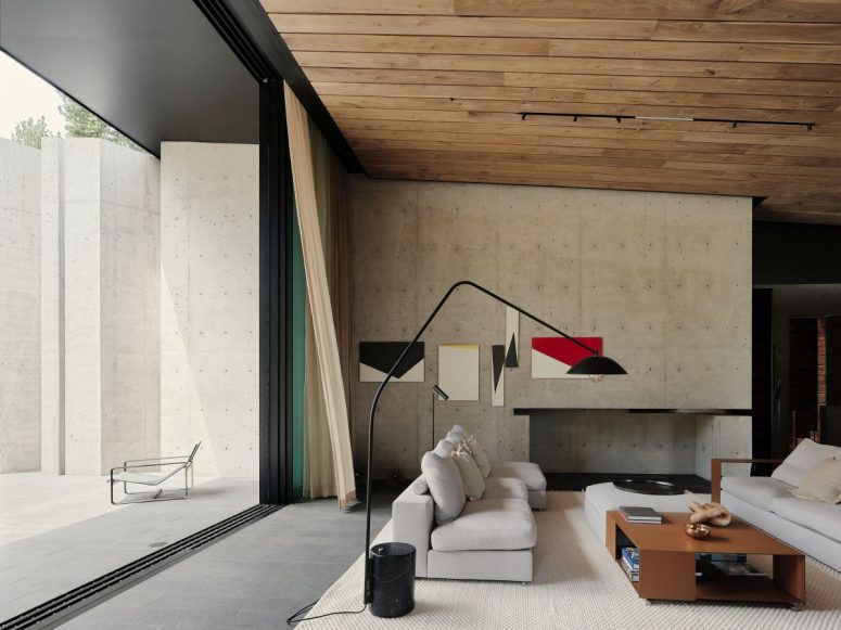 The living room features a concrete wall, a fireplace, a wooden ceiling and comfy furniture
