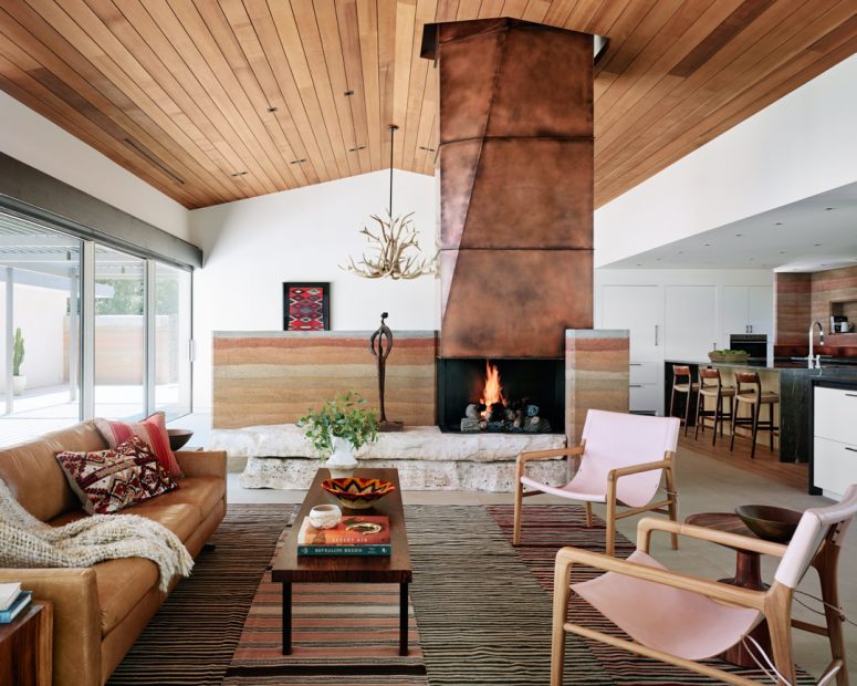 The living room shows off a gorgeous copper clad fireplace on stone, stylish furniture and layered rugs The living room shows off a gorgeous copper clad fireplace on stone, stylish furniture and layered rugs