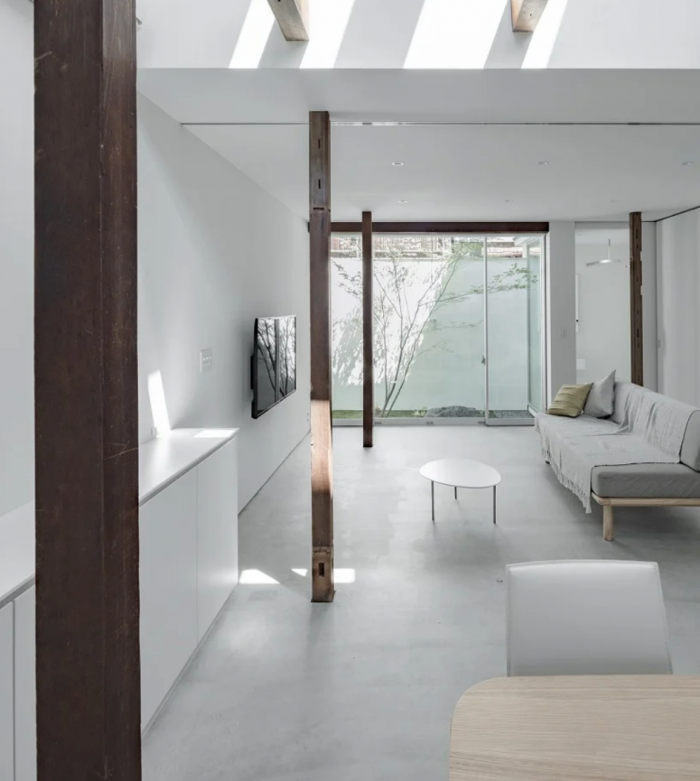 The living room is also neutral and minimalist, dark stained wooden beams add chic to the space and skylights bring outdoors inside The living room is also neutral and minimalist, dark stained wooden beams add chic to the space and skylights bring outdoors inside