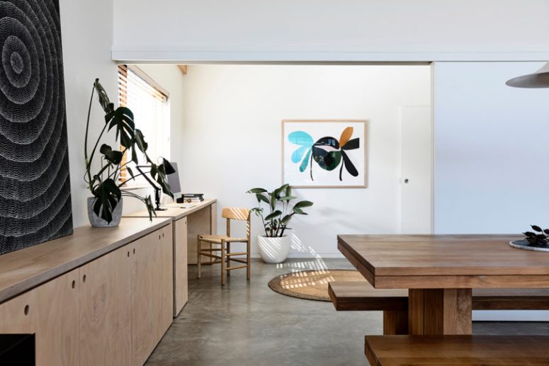 small workspace at home is a must There's a small work nook that is a continuation of a row of cabinets and is accented with a bright artwork