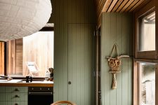 05 The kitchen and dining room are united into one space also clad with sage green wood and with matching furniture