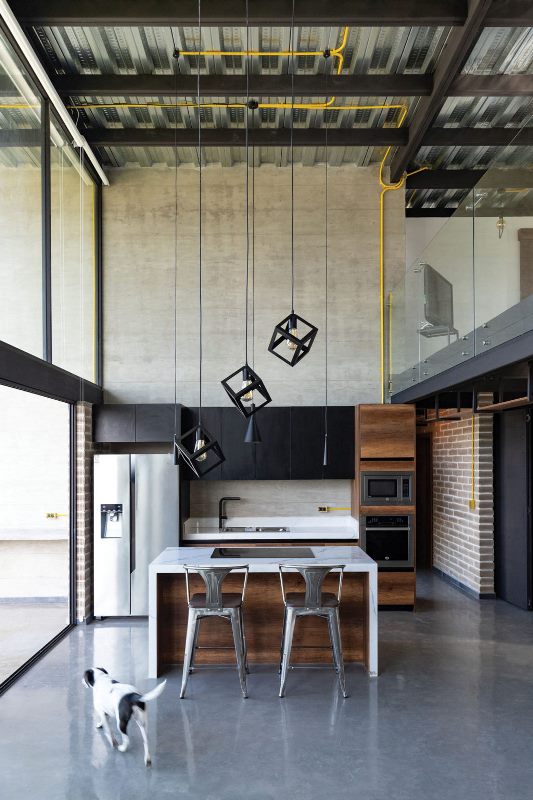 cute minimalist kitchen design in a modern house The kitchen is minimalist, it features black upper cabinets, a stained wood kitchen island and gorgeous pendant lamps