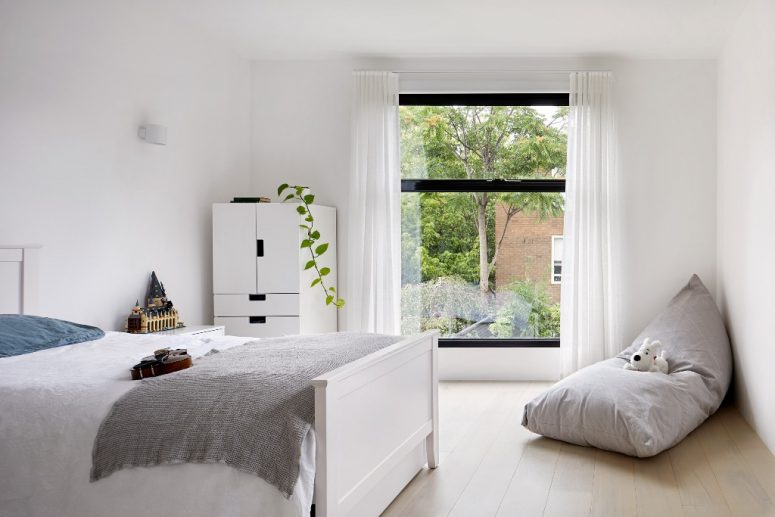 The kid's room is done in white, with several touches of muted colors and some greenery