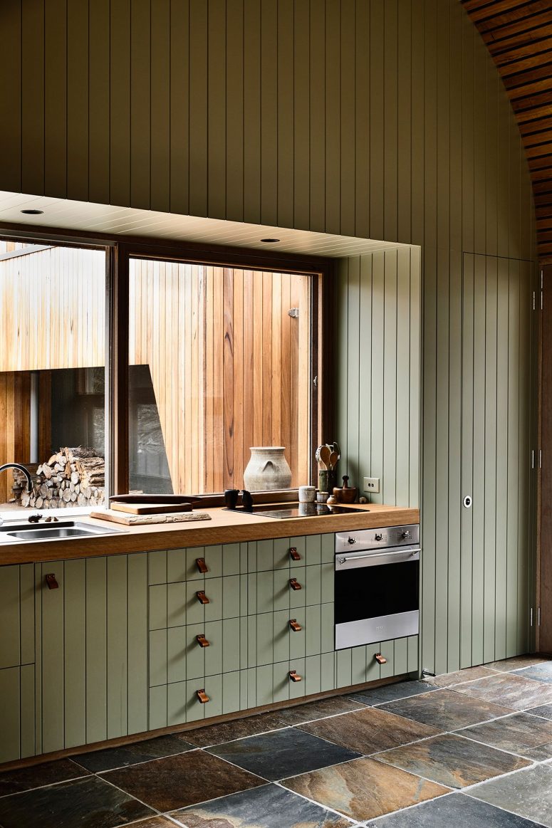 The kitchen shows off a large window instead of a backsplash and it brings much light inside