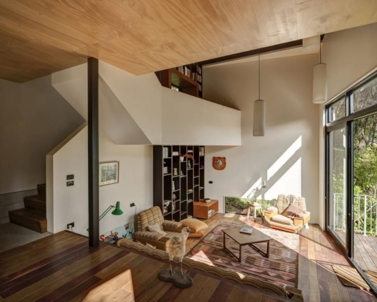 The living room is done with some comfortable furniture and a bookcase going up to the ceiling