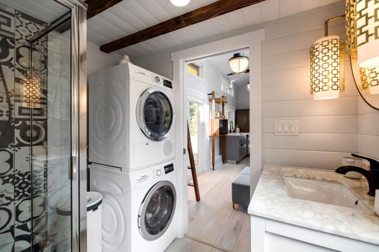 a small bathroom with smartly organized laundery space In the bathroom there’s a shower, a vanity, toilet and also space for stackable washer and dryer