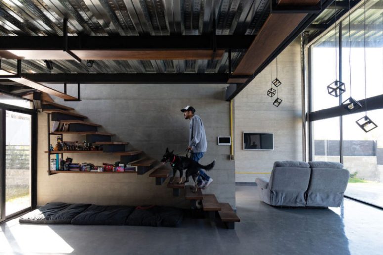 practical staircase with storage under stairs The living room is done with a TV, a sofa and some pendants, the staircase features much storage space and there's a daybed