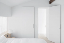 08 The bedroom is all-white, sleek and plain and looks aboslutely peaceful and welcoming
