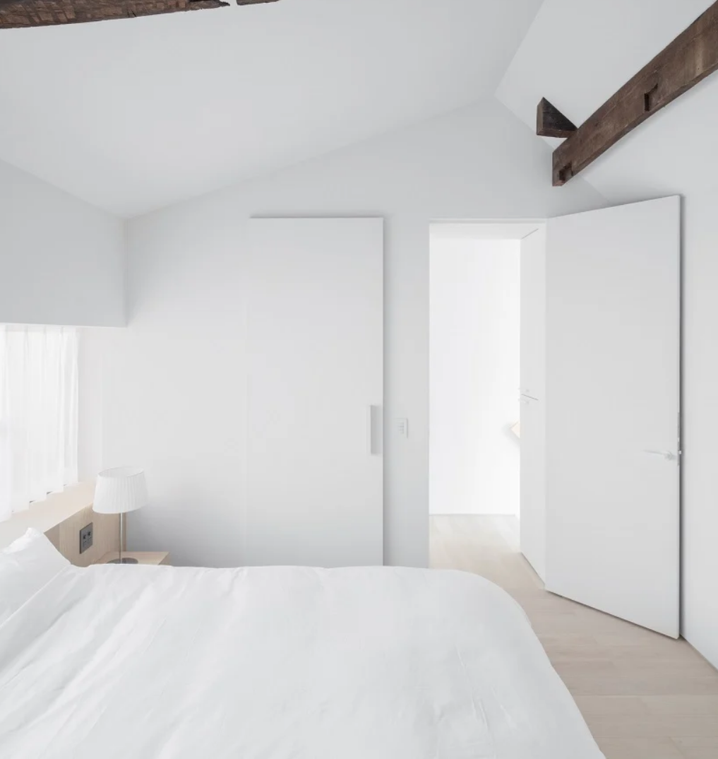 The bedroom is all white, sleek and plain and looks aboslutely peaceful and welcoming