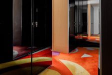 08 The hallway is colorful, with black shiny doors of wardrobes and colorful rugs