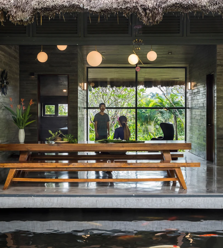 The indoor dining space is done with benches and a long table and can be also completely opened to the pond