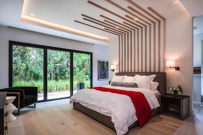 Another bedroom shows off a cool extended headboard, lots of light and a glazed wall