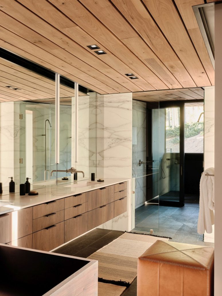A combination of wood, marble and glass turns the bathroom into a soothing and welcoming space