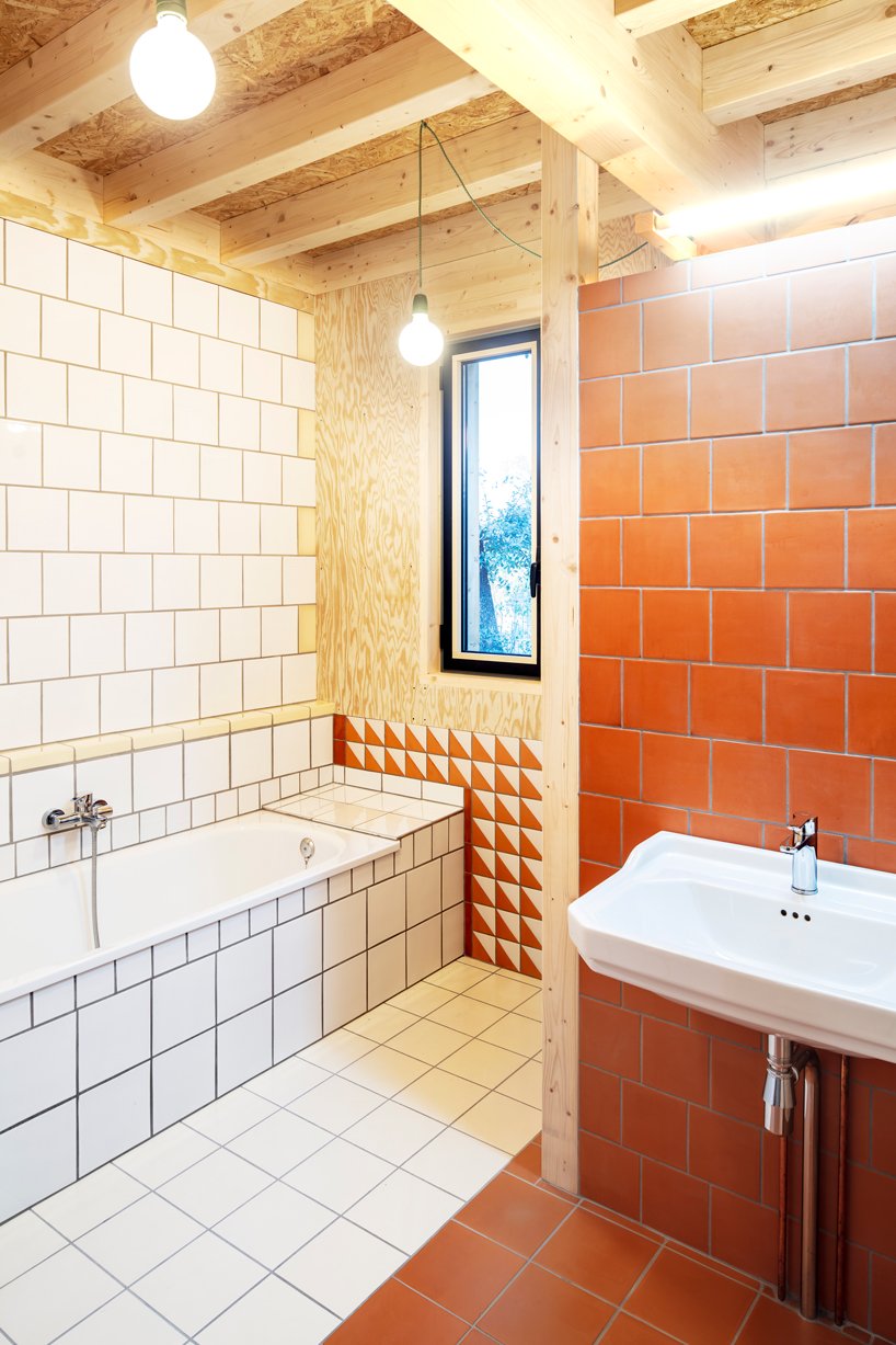 The bathroom is done with white and terracotta tiles and some timber again