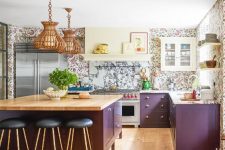 a whimsy kitchen with purple cabinets, a marble backsplash and floral print wallpaper plus rattan pendant lamps