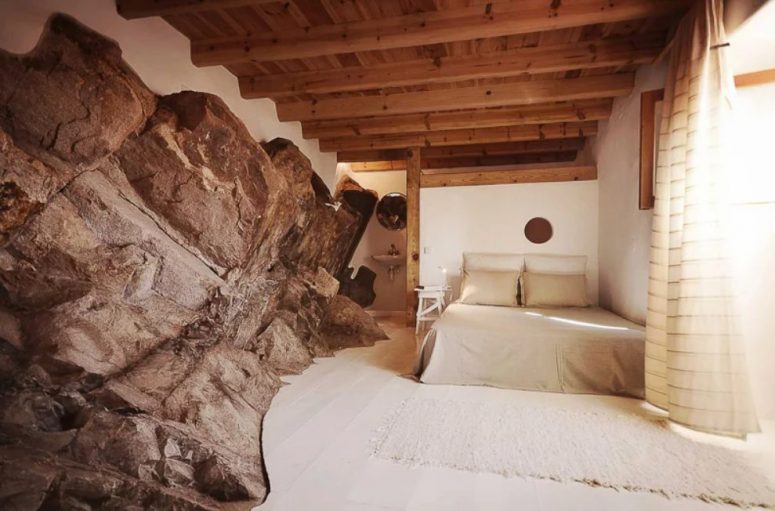 The bedroom features a fantastic rock formation and neutral decor and wood