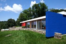 02 The house is done with red and blue touches and a mini fence is clad with stones, while the whole facade is glazed
