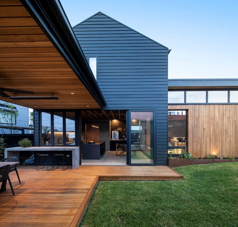 The house shows off a kitchen and dining space that can be opened to outdoors with sliding doors and an additional meal zone outdoors but under a roof The house shows off a kitchen and dining space that can be opened to outdoors with sliding doors and an additional meal zone outdoors but under a roof