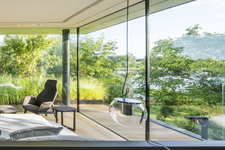 Large floor-to-ceiling windows and glass walls reveal the magnificent view of the river area