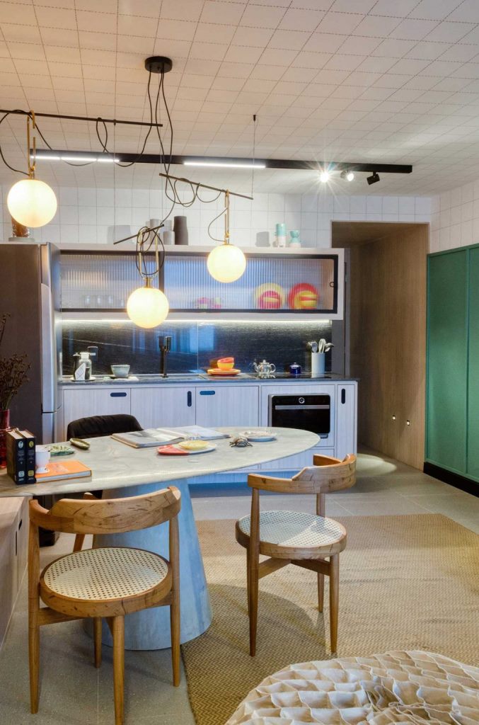 The ceiling is clad with white tiles, there are modern lamps hanging over the table and wicker chairs The ceiling is clad with white tiles, there are modern lamps hanging over the table and wicker chairs