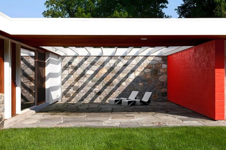 There's a semi covered terrace with stone walls and neutral loungers and footrests