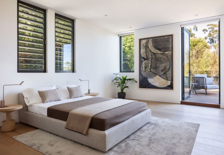 The bedroom is done in a neutral color scheme, with a statement artwork and there's an access to outdoors The bedroom is done in a neutral color scheme, with a statement artwork and there's an access to outdoors