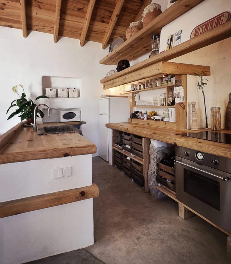 The kitchen is done with a white kitchen island, wooden countertops, metal appliances and additional light