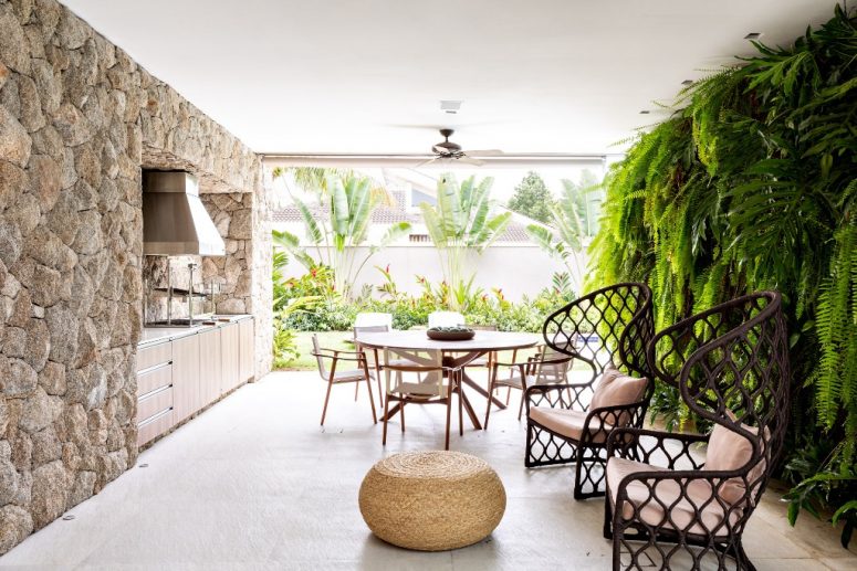 The outdoor dining zone is surrounded with a living wall and a stone wall