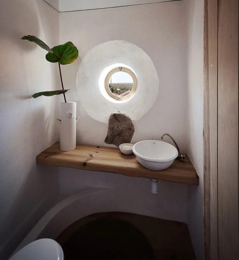 The powder room shows off a porthole window, a floating vanity with a sink