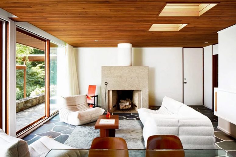 The sitting room is done in neutrals, with a stone hearth, white and neutral furniture and stained chairs