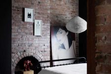12 A guest bedroom shows off red brick, quirky artworks and a comfy metal bed