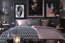 a bold and chic bedroom with black walls, a grey bed, grey and pink bedding, rose gold pendant lamps and pink touches