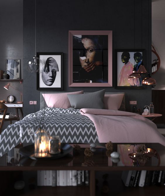 a bold and chic bedroom with black walls, a grey bed, grey and pink bedding, rose gold pendant lamps and pink touches