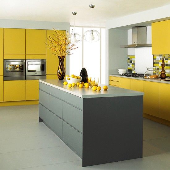 a bold kitchen with sleek mustard and grey cabinetry, grey countertops, a mustard and grey backsplash