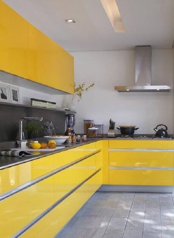 Dark grey gloss kitchen with small seating area and yellow accessories.