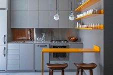 a chic minimalist kitchen with matte grey cabinetry, sunny yellow shelves and a matching counter for meals and drinks