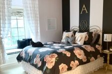 a glam and refined bedroom with a striped accent wall, black floral bedding, white ruffle curtains and exquisite furniture