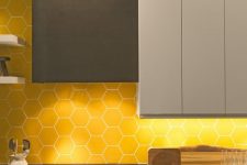 a minimalist kitchen with grey dove grey and wooden cabinets, a yellow hex tile backsplash and concrete countertops