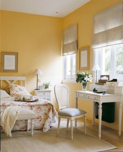a romantic sunny yellow bedroom with refined vintage white furniture, dove grey textiles and floral bedding
